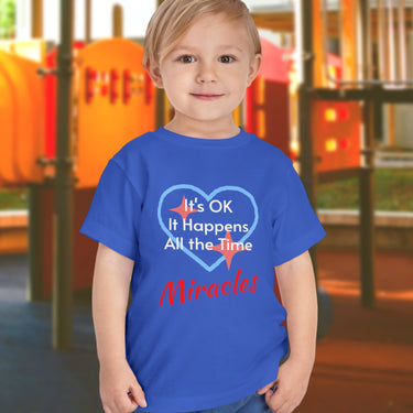 Bella+Canvas toddler t-shirt with “Miracles Happen” design and uplifting message, soft cotton, breathable and durable, Christian apparel for everyday wear and family matching, toddler boy in blue t-shirt